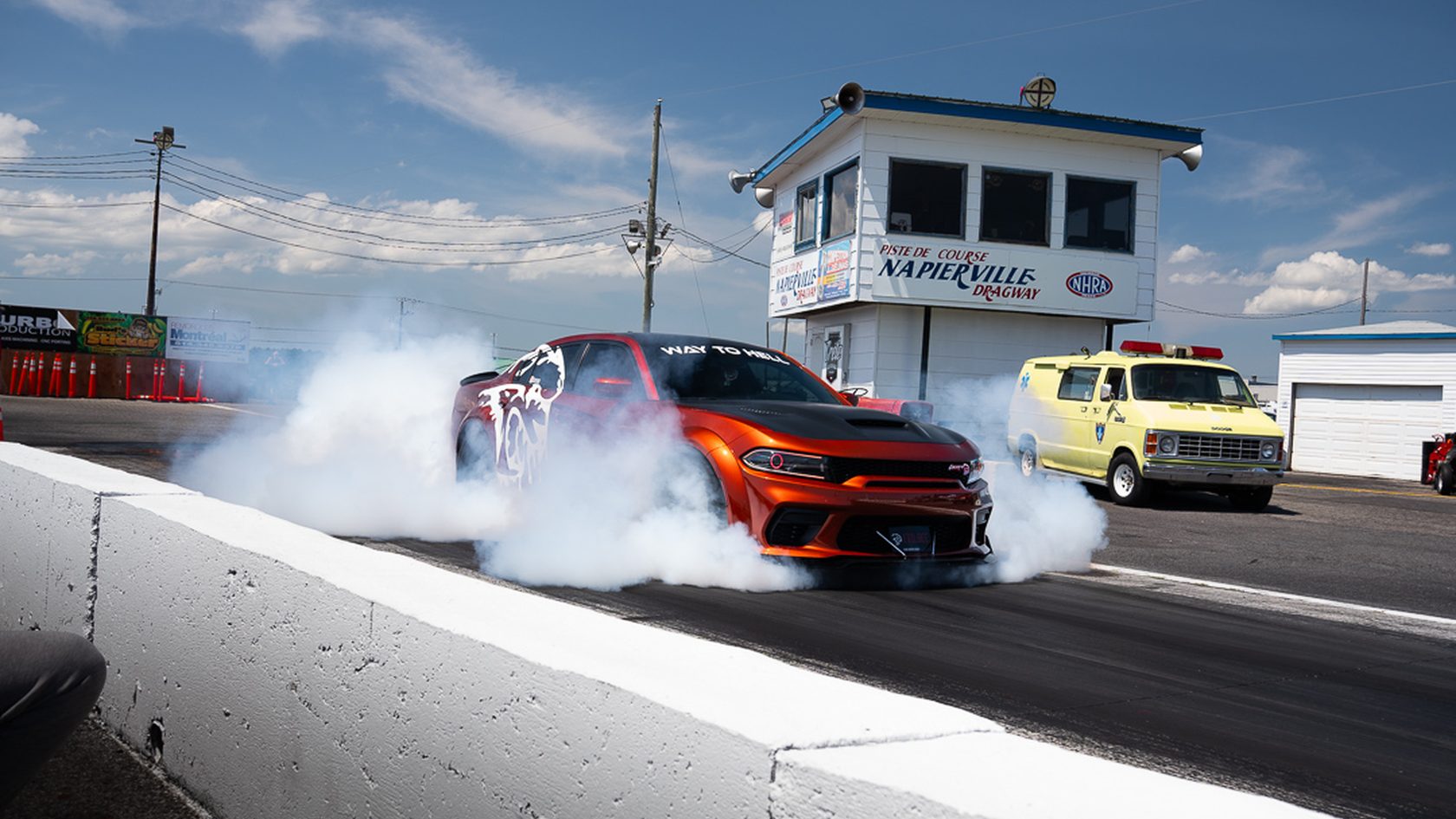 A Dodge Charger lighting up the tyres at the line